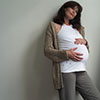 Pregnant woman leaning against a wall