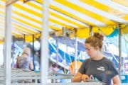A woman looking at an animal at a fair