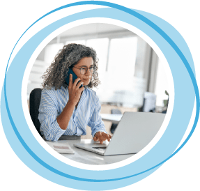 Woman on phone looking at a laptop computer