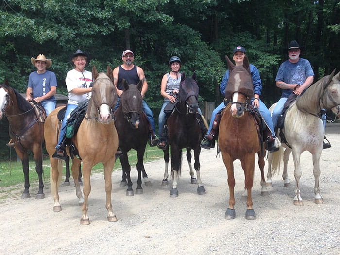 group of horseback riders posing on gravel road