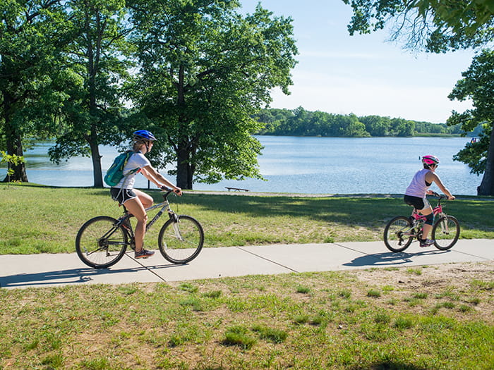 two bikers on concrete path