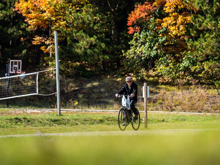 Park guest biking near a volleyball court
