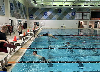 men practice diving into a pool