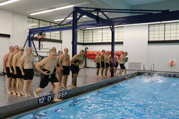 Group of people standing in line, jumping into pool