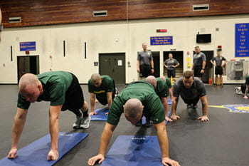 people performing push ups in a gym