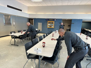 two people straightening cafeteria tables