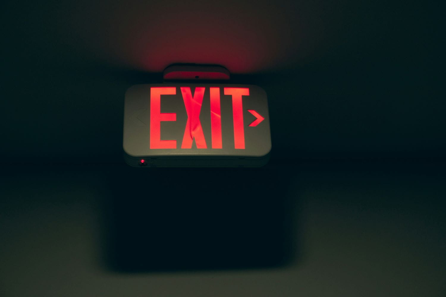 A glowing red exit sign in darkness