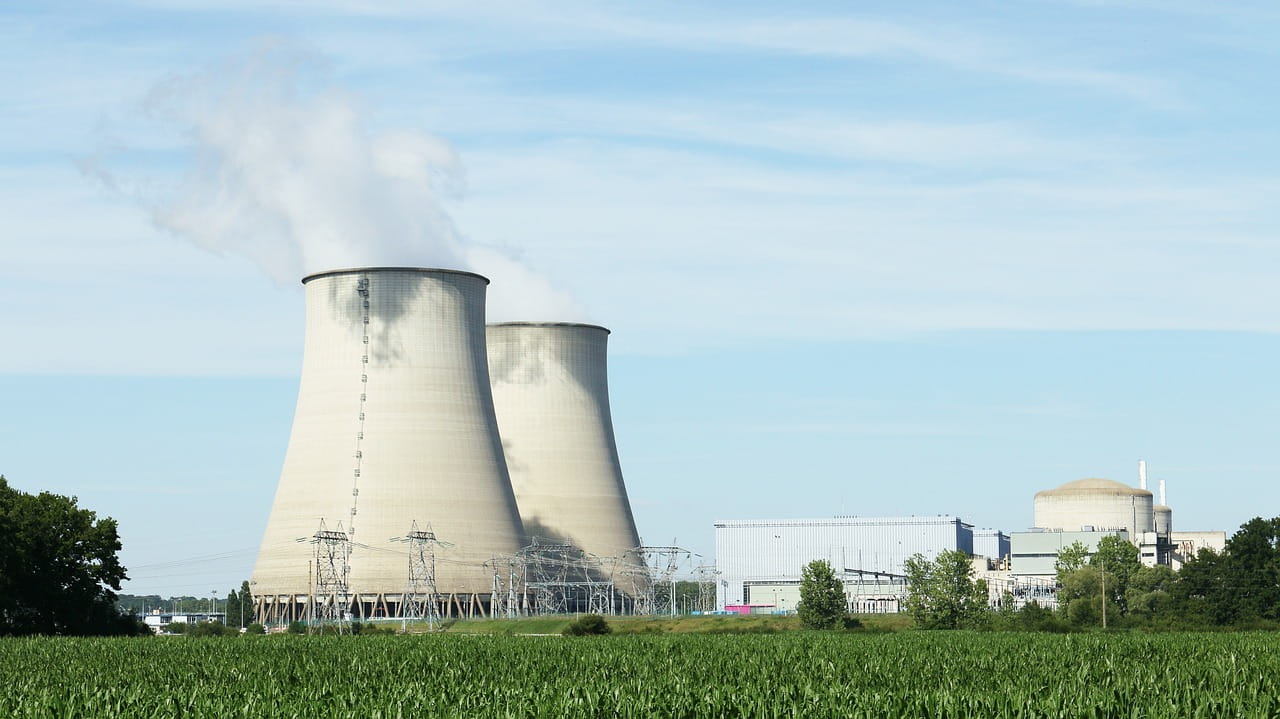 Two tall chimneys of a nuclear power plant against a blue sky