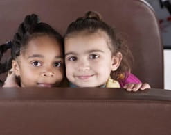 two little girls sitting next to each other with their heads touching