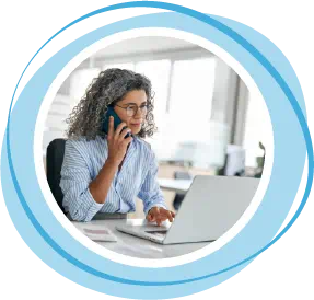 Woman on phone looking at a laptop computer