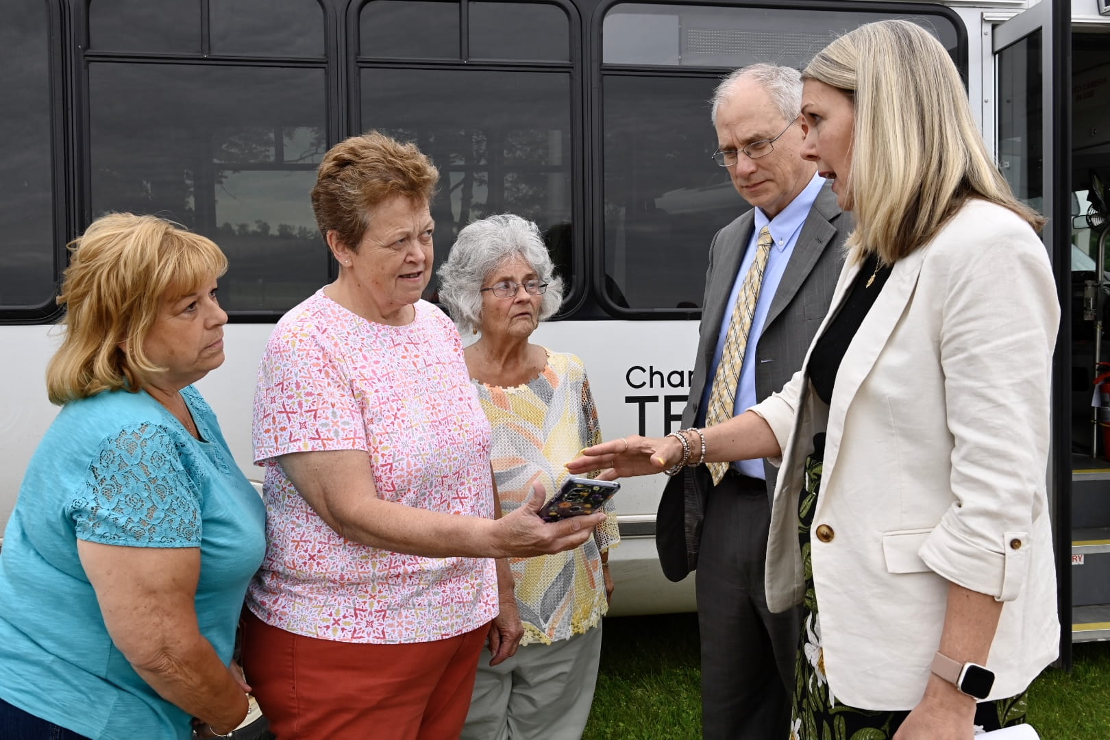 MDOT Office of Passenger Transportation Administrator Jean Ruestman (right), and USDOT SMART Program Director Stan Caldwell (second from right) meet with transit riders at the June 28 rural transit media event in Boyne City. (MDOT Photo)     