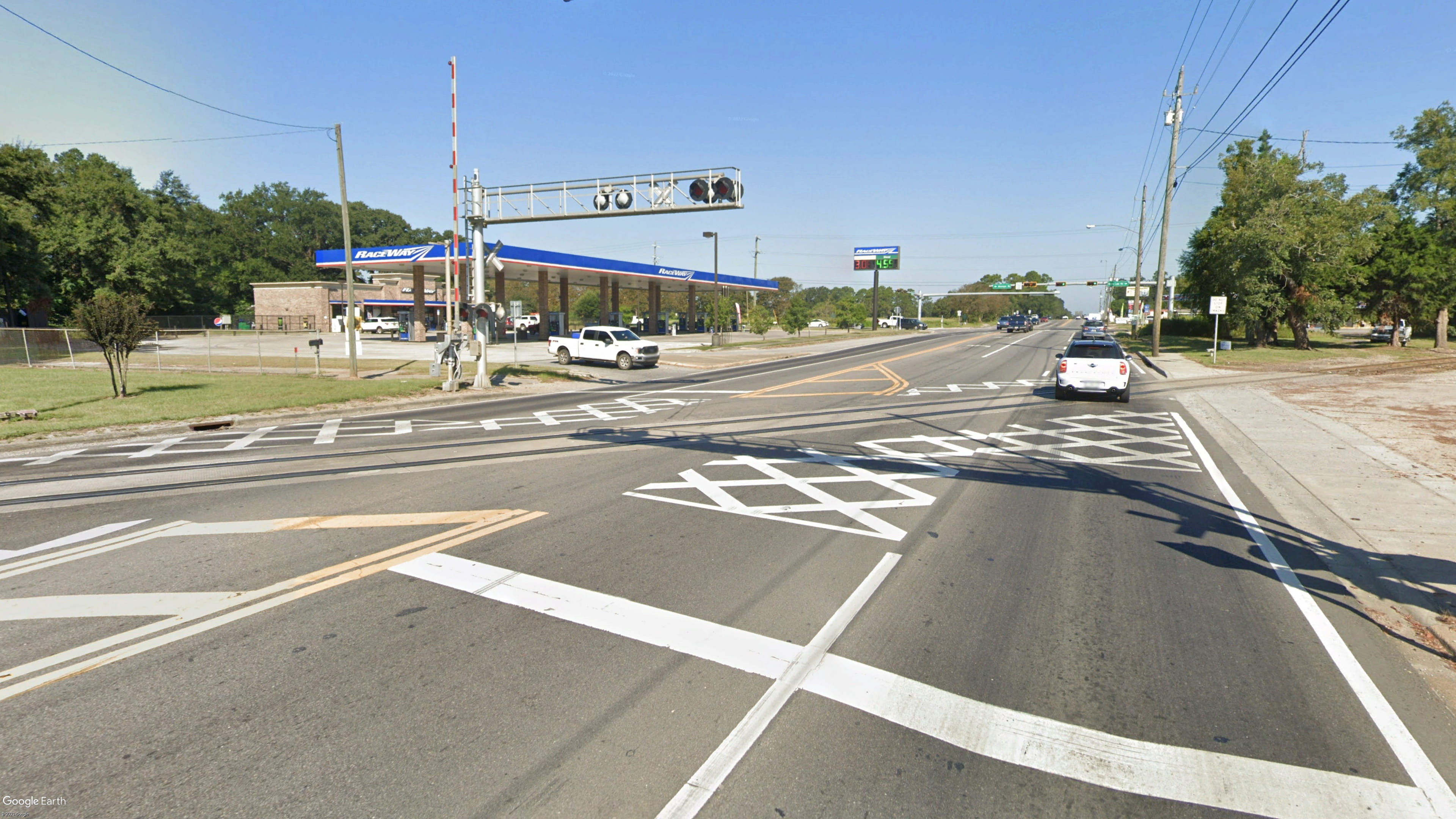 An image of a railroad crossing with white Xs painted onto the asphalt roadway to make the crossing more visible.