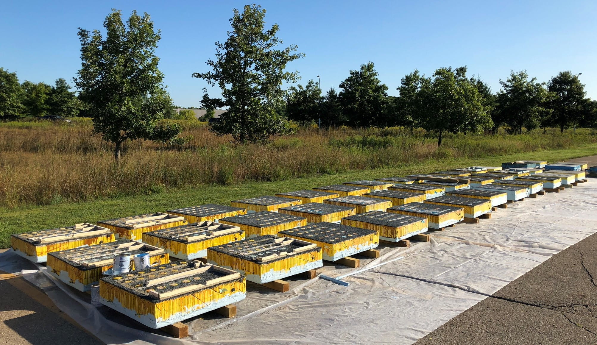 Two rows of concrete test pallets in outdoor sunny conditions.