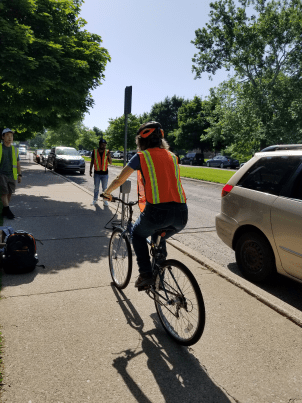 A project team member rides a bicycle fitted with a pedestrian and cyclist counter.