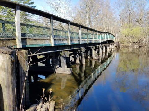Old railroad bridge footings carry the Mike Levine Lakelands Trail across the Huron River