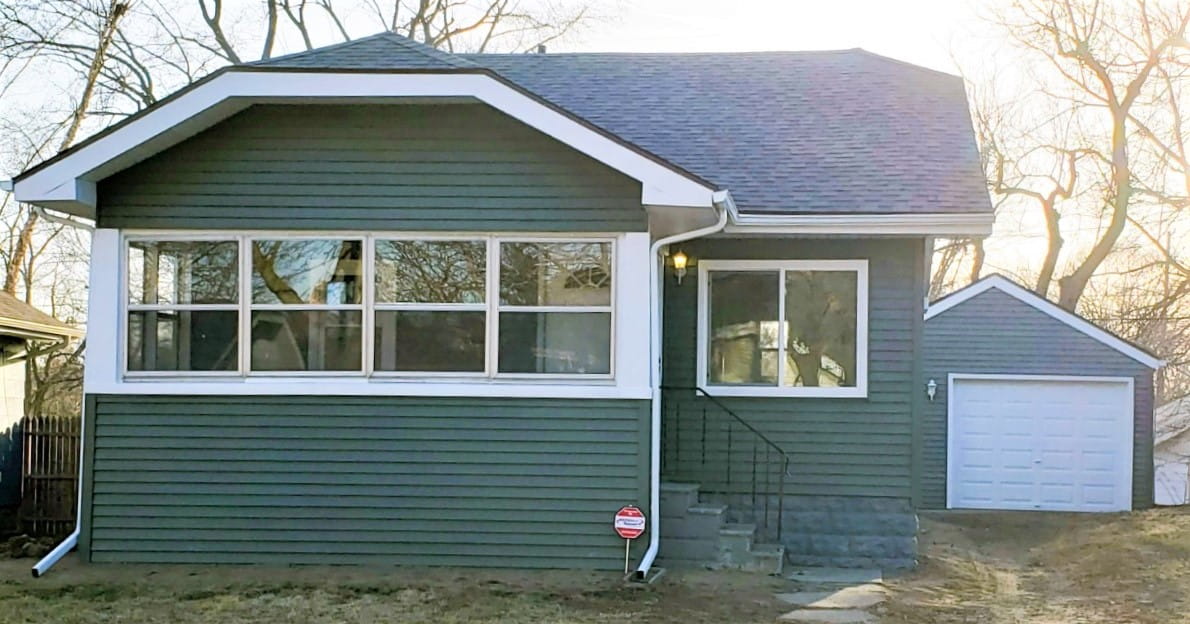 Front of house after abatement with new windows and siding