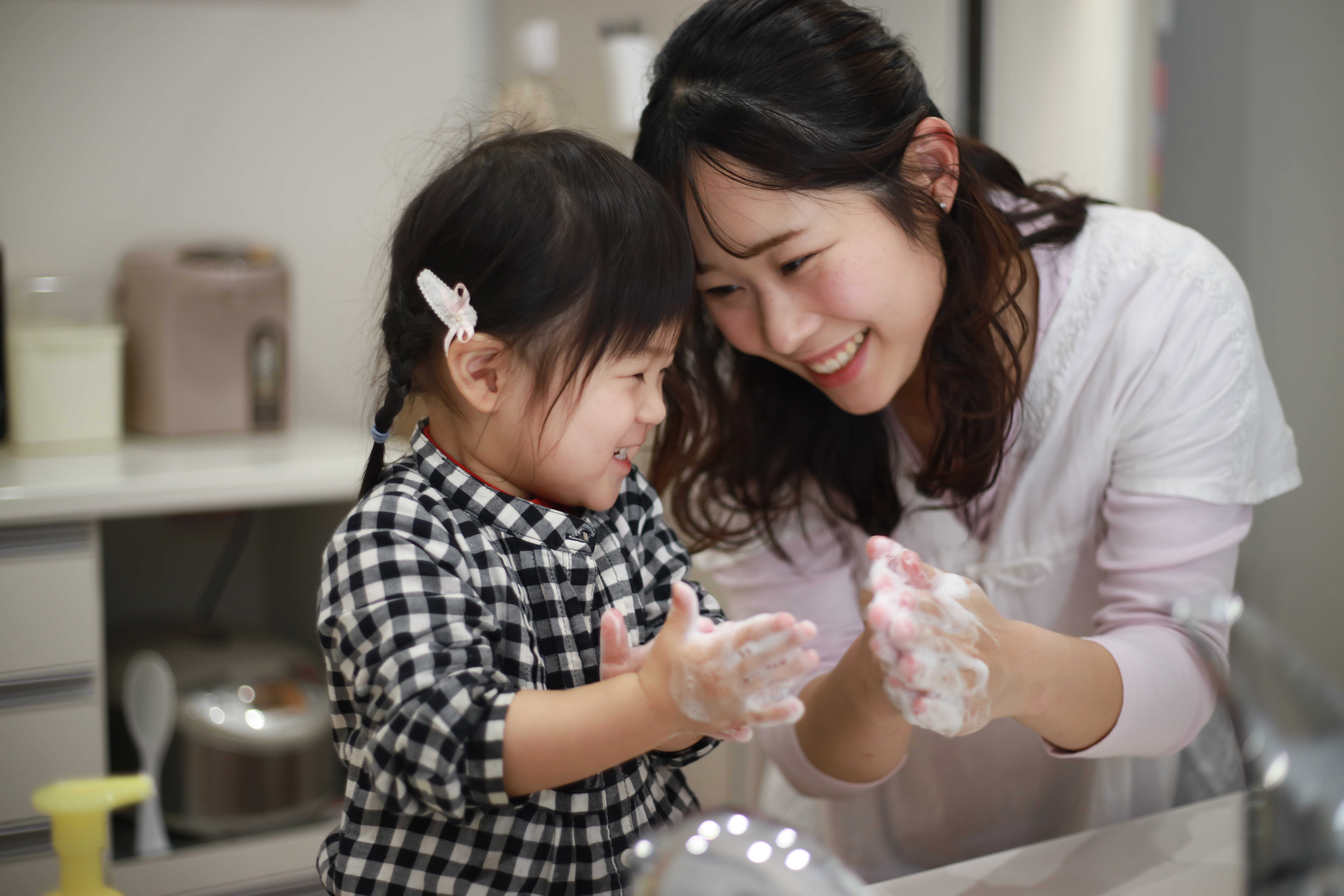 Mother and daughter washing hands together