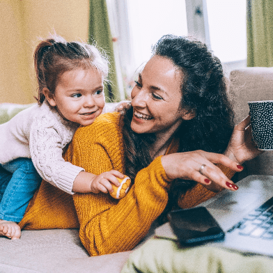 Photograph of a little girl climbing onto her mother's back