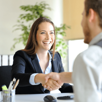 Photograph of two people shaking hands at a business meeting