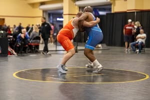 Gude and another man wrestling inside of a gym