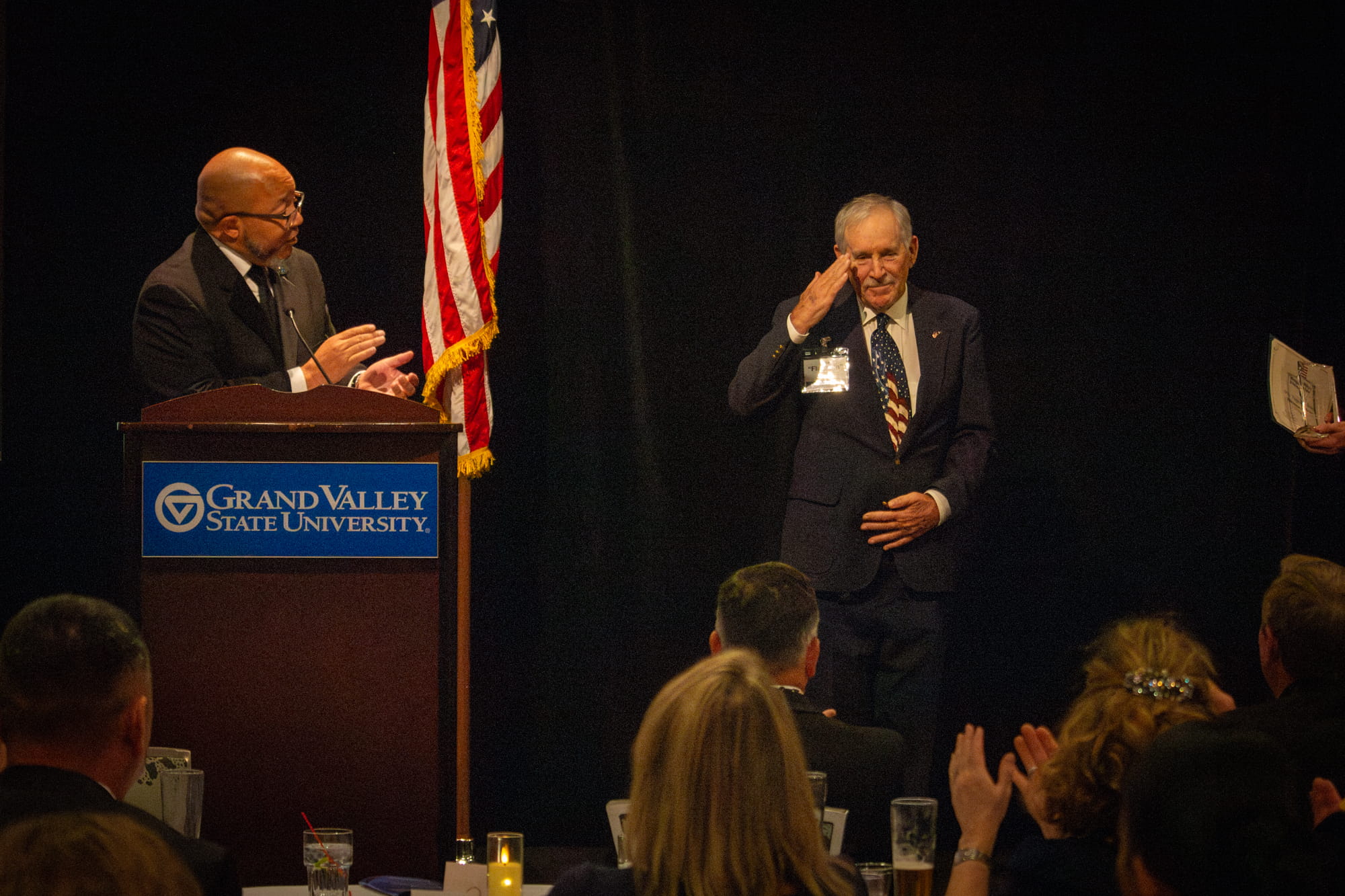 light-skinned male saluting on stage