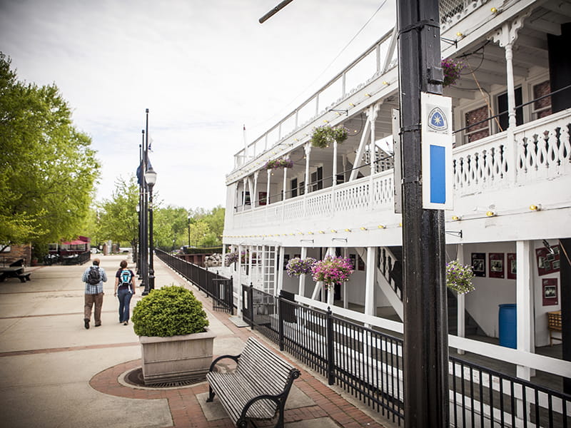 An old-fashioned riverboat is docked in a river
